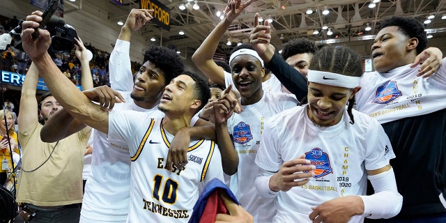The East Tennessee State basketball team celebrates their win over Wofford for the NCAA men's basketball Southern Conference championship, Monday, March 9, 2020, in Asheville, N.C. (AP Photo/Kathy Kmonicek)