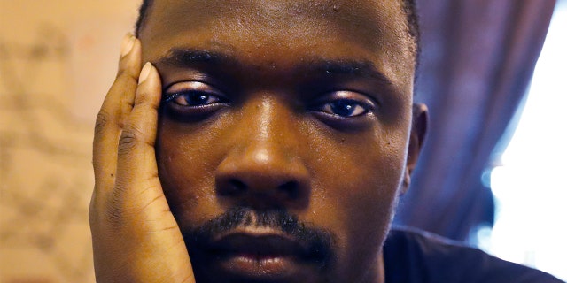 In this Thursday, Feb. 27, 2020, photo, Richard Butler poses for a portrait in an apartment that a friend is letting him and his fiance live in on Chicago's Southside. (AP Photo/Charles Rex Arbogast)