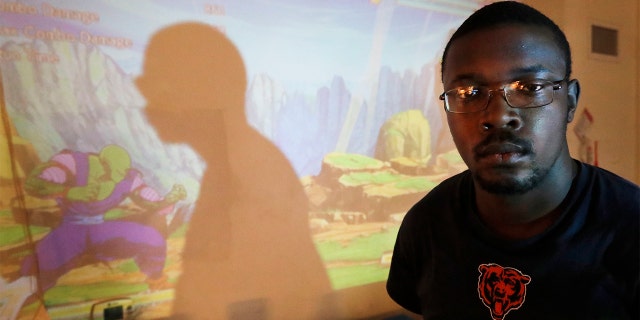In this Thursday, Feb. 27, 2020, photo, Richard Butler poses for a portrait during a break playing a video game in an apartment that a friend is letting him and his fiance live in on Chicago's Southside. Having food stamps offers Butler a stability he's rarely known in his 25 years. (AP Photo/Charles Rex Arbogast)