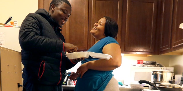 In this Thursday, Feb. 27, 2020, photo, Richard Butler and his fiance Amber laugh while they have breakfast in an apartment a friend is letting them live in on Chicago's Southside. (AP Photo/Charles Rex Arbogast)
