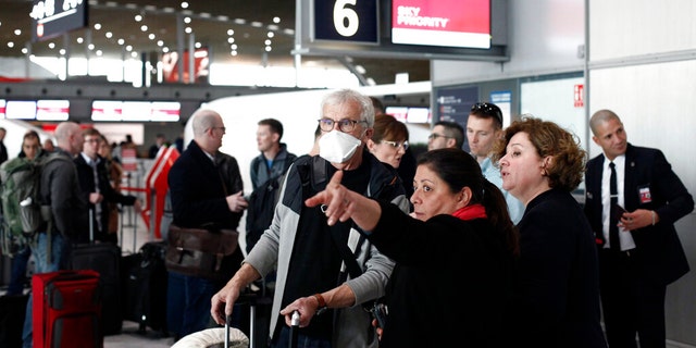 Passengers await flights out of Charles de Gaulle airport, north of Paris, on March 12, 2020, following President Trump's decision to restrict travel from 26 European nations.