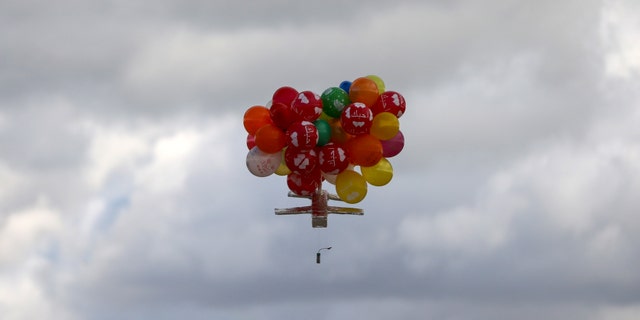 Balloons carrying an incendiary device floats after being released by masked Palestinians near Gaza's Bureij refugee camp, along the Israel-Gaza border fence, on February 10, 2020. (Photo by MAHMUD HAMS / AFP) (Photo by MAHMUD HAMS/AFP via Getty Images)