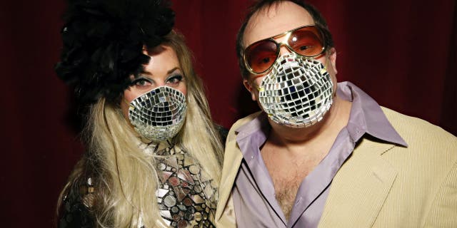 Allison Eden and Gary Goldenstein wear decorated masks inspired by the Coronavirus disease (COVID-19) threats during "Studio 54: Night Magic" Opening Night at the Brooklyn Museum on March 11, 2020.