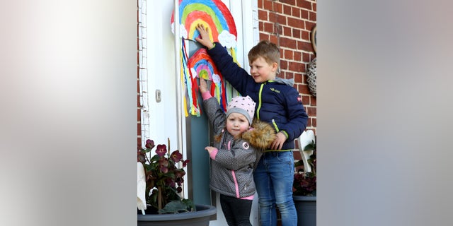 In this March 27 photo, children at home in Moorrege near Hamburg, Germany, hang rainbow artwork outside. (Martin Rose/Getty Images)