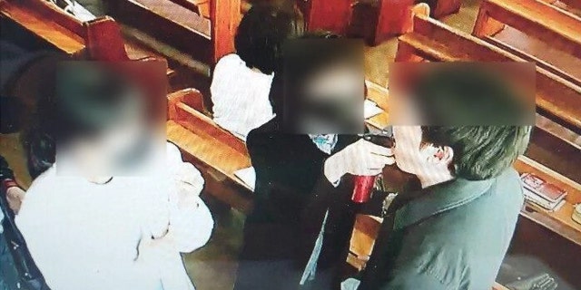 A church official can be seen spraying saltwater into the mouth of a church member during a service on March 8.