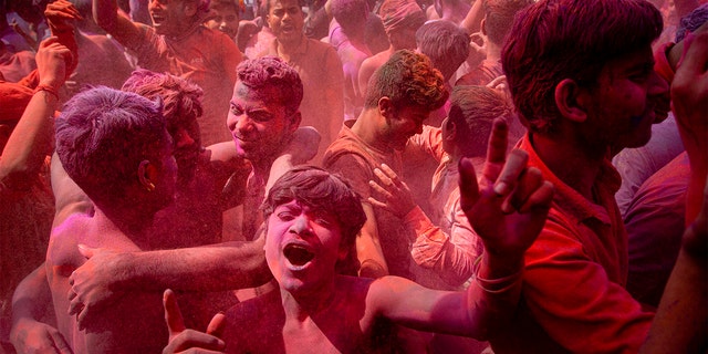 Indians dance and throw colored powder during Holi festival celebrations in Gauhati, India, Tuesday. The festival heralds the arrival of spring. (AP Photo/Anupam Nath)