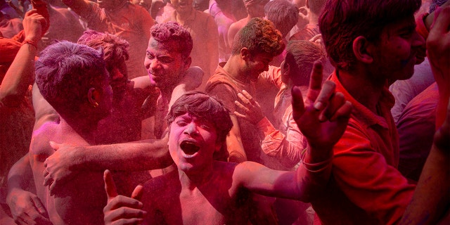 Indians dance and throw colored powder during Holi festival celebrations in Gauhati, India, Tuesday. The festival heralds the arrival of spring. (AP Photo/Anupam Nath)