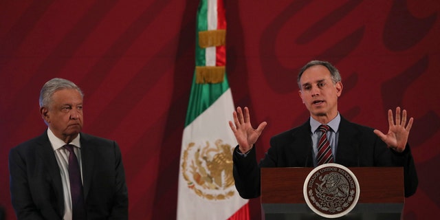 Mexico's President Andres Manuel Lopez Obrador, left, watches his Health Sub Secretary Hugo Lopez speak about hand washing as one of the ways to help prevent the spread of the new coronavirus during the president's daily news conference in Mexico City, early Thursday, March 19, 2020. (AP Photo/Fernando Llano)
