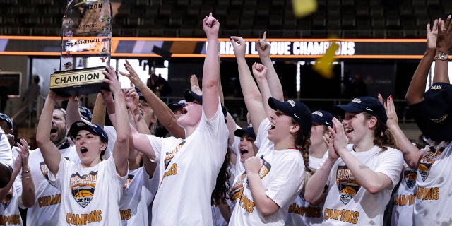 Members of the IUPUI team hoist the trophy after they defeated Green Bay 61-37 in an NCAA college basketball game for the Horizon League women's tournament championship in Indianapolis, Tuesday, March 10, 2020. (AP Photo/Michael Conroy)