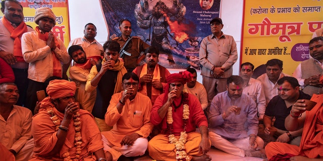 Members of All India Hindu Mahasabha drink cow urine as they attend a gaumutra (cow urine) party, which according to them helps warding off coronavirus disease (COVID-19), in New Delhi, India Saturday. REUTERS/Danish Siddiqui