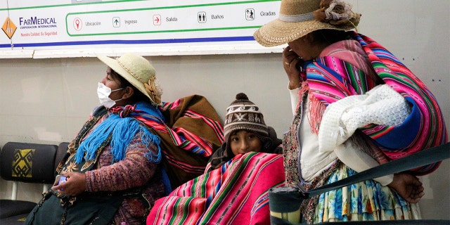 Indigenous women with children wait at the Boliviano Holandes hospital after Bolivia's government declared a national emergency and suspension of school classes, in El Alto outskirts of La Paz, Bolivia, March 12, 2020. REUTERS/David Mercado - RC2IIF9X7ZQB