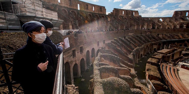 Tourists with masks visiting the Colosseum in Rome on Saturday. (AP Photo/Andrew Medichini)