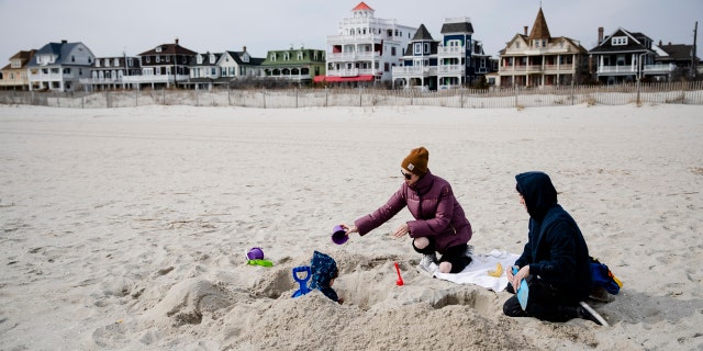 Matt and Anna Mason play with their son, Oliver, on the beach in Cape May, N.J., Wednesday, March 18, 2020. The Masons live and work in Cape May.