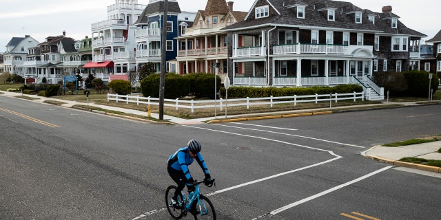 A cyclist rides a bicycle in Cape May, N.J., Wednesday, March 18, 2020.