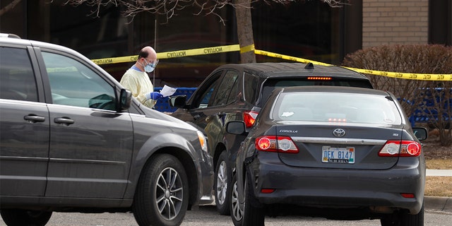 A healthcare worker screens people for COVID-19, the disease that is caused by the new coronavirus, at a drive-through station set up in the parking lot of the Beaumont Hospital in Royal Oak, Mich. on March 16. Skylar Herbert, the first child to die from the coronavirus in the state on Sunday had been admitted to the hospital. (AP Photo/Paul Sancya)