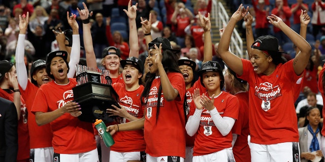 North Carolina State players celebrate with the championship trophy after defeating Florida State in the NCAA college basketball championship game at the Atlantic Coast Conference women's tournament in Greensboro, N.C., Sunday, March 8, 2020. (AP Photo/Gerry Broome)
