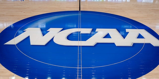 FILE - In this March 18, 2015, file photo, the NCAA logo is displayed at center court as work continues at The Consol Energy Center in Pittsburgh, for the NCAA college basketball tournament.