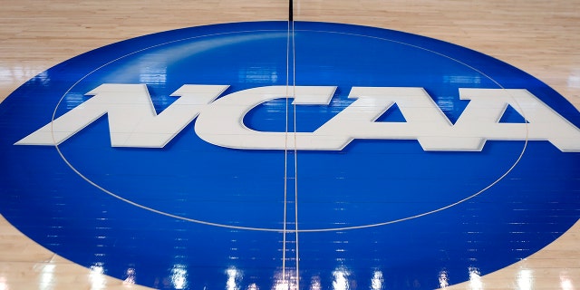 FILE - In this March 18, 2015, file photo, the NCAA logo is displayed at center court as work continues at The Consol Energy Center in Pittsburgh, for the NCAA college basketball tournament.