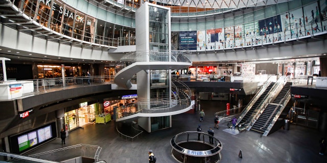 A pedestrian passes a nearly empty Fulton Center station as businesses are closed due to coronavirus concerns, Monday, March 16, 2020, in New York.