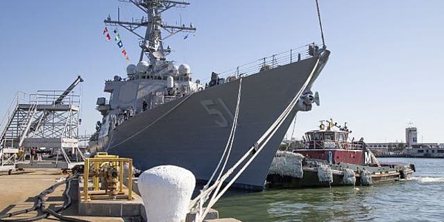A tug boat pulls along side the guided-missile destroyer USS Arleigh Burke (DDG 51) on Jan. 27, 2020.