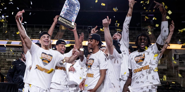 Northern Kentucky celebrates with the trophy after a 71-62 win over Illinois-Chicago in an NCAA college basketball game for the Horizon League men's tournament championship in Indianapolis, Tuesday, March 10, 2020. (AP Photo/Michael Conroy)
