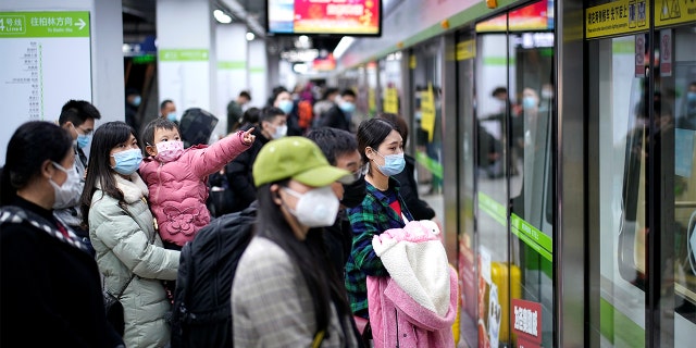 People wearing face masks wait for a subway train on the first day the city's subway services resumed following the novel coronavirus disease [COVID-19) outbreak, in Wuhan of Hubei province, on March 28, 2020.  REUTERS/Aly Song 