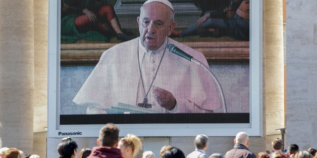 Faithful watch Pope Francis deliver the Angelus prayer on a giant screen, in St. Peter's Square, at the Vatican, Sunday, March 8, 2020. Italy's Prime Minister Giuseppe Conte announced a sweeping coronavirus quarantine early Sunday, restricting the movements of about a quarter of the country's population in a bid to limit contagions at the epicenter of Europe's outbreak. (AP Photo/Andrew Medichini)