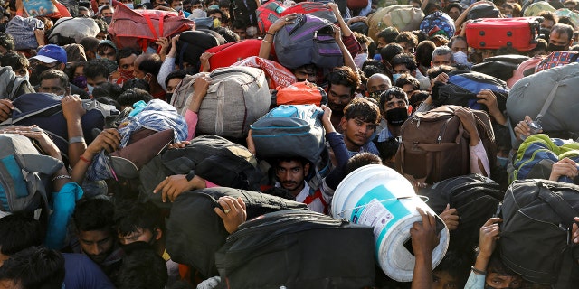 Migrant workers crowd up outside a bus station as they wait to board buses to return to their villages during a 21-day nationwide lockdown to limit the spreading of coronavirus disease in Ghaziabad, on the outskirts of New Delhi, India, on March 28. (REUTERS/Anushree Fadnavis)