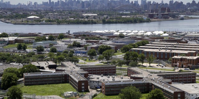 In a June 20, 2014, file photo, the Rikers Island jail complex stands in New York with the Manhattan skyline in the background. (AP Photo/Seth Wenig, File)