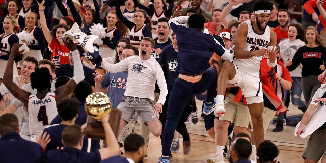 Robert Morris fans run onto the court as the team celebrates following a 77-67 win over St. Francis in an NCAA college basketball game for the Northeast Conference men's tournament championship in Pittsburgh, Tuesday, March 10, 2020. (AP Photo/Gene J. Puskar)