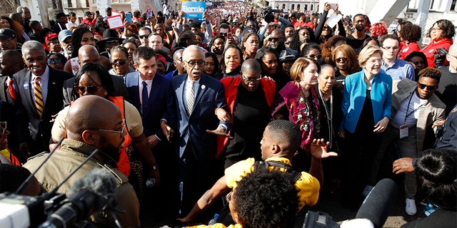 From left to right: Pete Buttigieg, the Rev. Al Sharpton, Amy Klobuchar and Elizabeth Warren walking across the Edmund Pettus Bridge in Selma, Ala., on Sunday. (AP Photo/Patrick Semansky)
