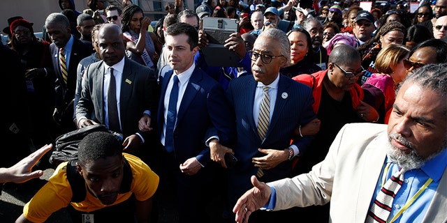 Presidential candidate and former South Bend, Ind., Mayor Pete Buttigieg walking across the Edmund Pettus Bridge in Selma, Ala., with the Rev. Al Sharpton on Sunday. (AP Photo/Patrick Semansky)