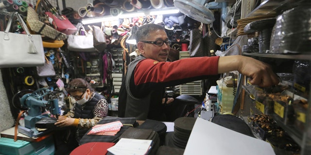 In this March 25, 2020 photo, South Korean shoe repairman Kim Byung-rok and his wife Kwon Jeom-deuk work at their shop in Seoul, South Korea. (AP Photo/Ahn Young-joon)