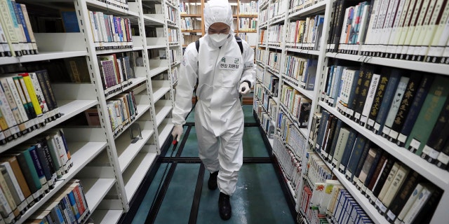 An army soldier sprays disinfectant to curb the spread of the coronavirus at a library in Daegu, South Korea, Wednesday, March 25, 2020.