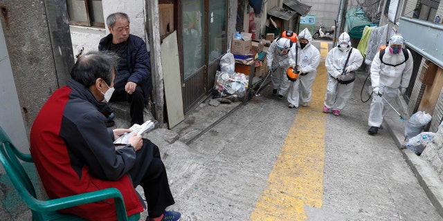 Workers spray disinfectant as a precaution against coronavirus in Seoul, South Korea, Wednesday, March 25, 2020.
