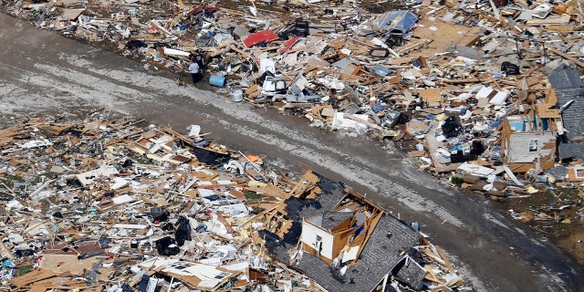 A road separates properties filled with debris Tuesday, March 3, 2020, near Lebanon, Tenn.