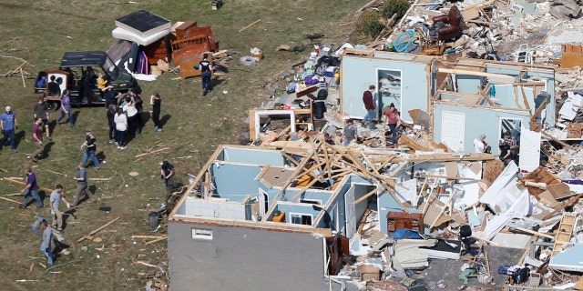 People work to salvage items Tuesday, March 3, 2020, near Cookeville, Tenn.