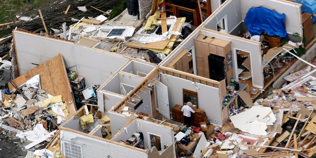 A woman salvages item from a destroyed home Tuesday, March 3, 2020, near Lebanon, Tenn.