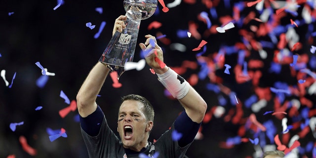In this Feb. 5, 2017, file photo, New England Patriots' Tom Brady raises the Vince Lombardi Trophy after defeating the Atlanta Falcons in overtime at the NFL Super Bowl 51 football game in Houston. Pro football today is a $17 billion-a-year business.