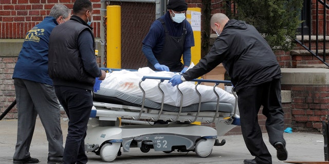 Health workers wheel a deceased person outside the Brooklyn Hospital Center, during the coronavirus disease outbreak, in the Brooklyn borough of New York City, on March 30, 2020. (REUTERS/Brendan McDermid)