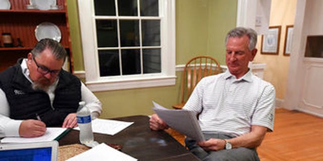 Alabama U.S. Senate candidate Tommy Tuberville, right, watches election returns and works on his speech in the main house at Auburn Oaks Farm, the site of his election party, Tuesday, March 3, 2020. Tuberville is in a tight race with seven competitors for the Senate seat. (Joe Songer/The Birmingham News via AP)