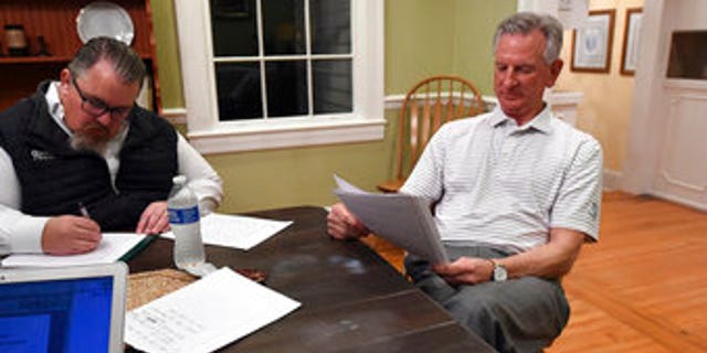 Alabama U.S. Senate candidate Tommy Tuberville, right, watches election returns and works on his speech in the main house at Auburn Oaks Farm, the site of his election party, Tuesday, March 3, 2020. Tuberville is in a tight race with seven competitors for the Senate seat. (Joe Songer/The Birmingham News via AP)