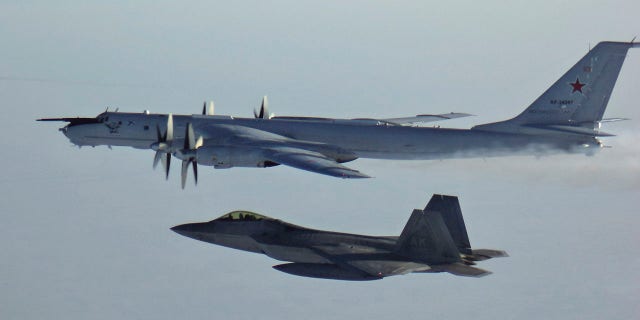 FILE PHOTO: In this Monday, March 9, 2020 photo released by the North American Aerospace Defense Command (NORAD), a Russian Tu-142 maritime reconnaissance aircraft, top right, is intercepted near the Alaska coastline.