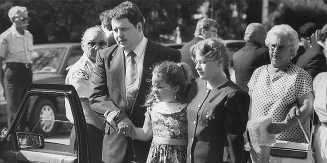 Todd and Diana Moore, parents of murder victim Michael Moore, with 9-yr-old daughter Dawn walking outside the Holy Cross Episcopal Church at Michael's funeral.