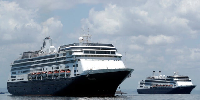 The Zaandam cruise ship, left, and the Rotterdam, seen here outside of Panama last week, were waiting outside of U.S. waters for clearance to disembark in Florida. (AP Photo/Arnulfo Franco)