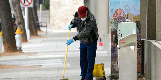 A man cleans a sidewalk in downtown Sacramento, Calif., Monday, March 23, 2020. (AP)