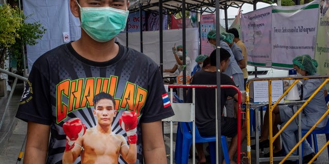 ​​​​​​​A Muay Thai boxing fighter stands in front of makeshift screening facility outside Rajadamnern boxing stadium in Bangkok, Thailand, March 19, 2020. (Associated Press)