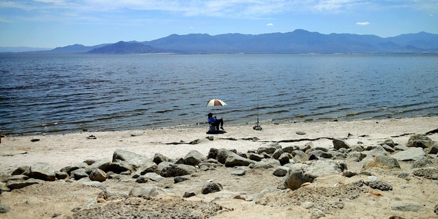 A man fishes along the receding banks of the Salton Sea near Bombay Beach, Calif., in 2015. (AP Photo/Gregory Bull, File)