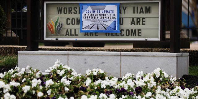 A sign displaying modified church services, due to the coronavirus disease (COVID-19) outbreak, is posted over a signboard outside Mount Vernon Place Methodist Church in the Mount Vernon neighborhood of Washington, U.S., March 19, 2020. REUTERS/Tom Brenner - RC27NF9YU070