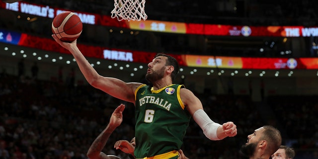 In this Sept. 15, 2019 file photo, Australia's Andrew Bogut puts a shot over Amat M'Baye, left, and France's Ivan Fournier during their third-place match for the FIBA ​​Basketball World Cup at Cadillac Arena in Beijing.